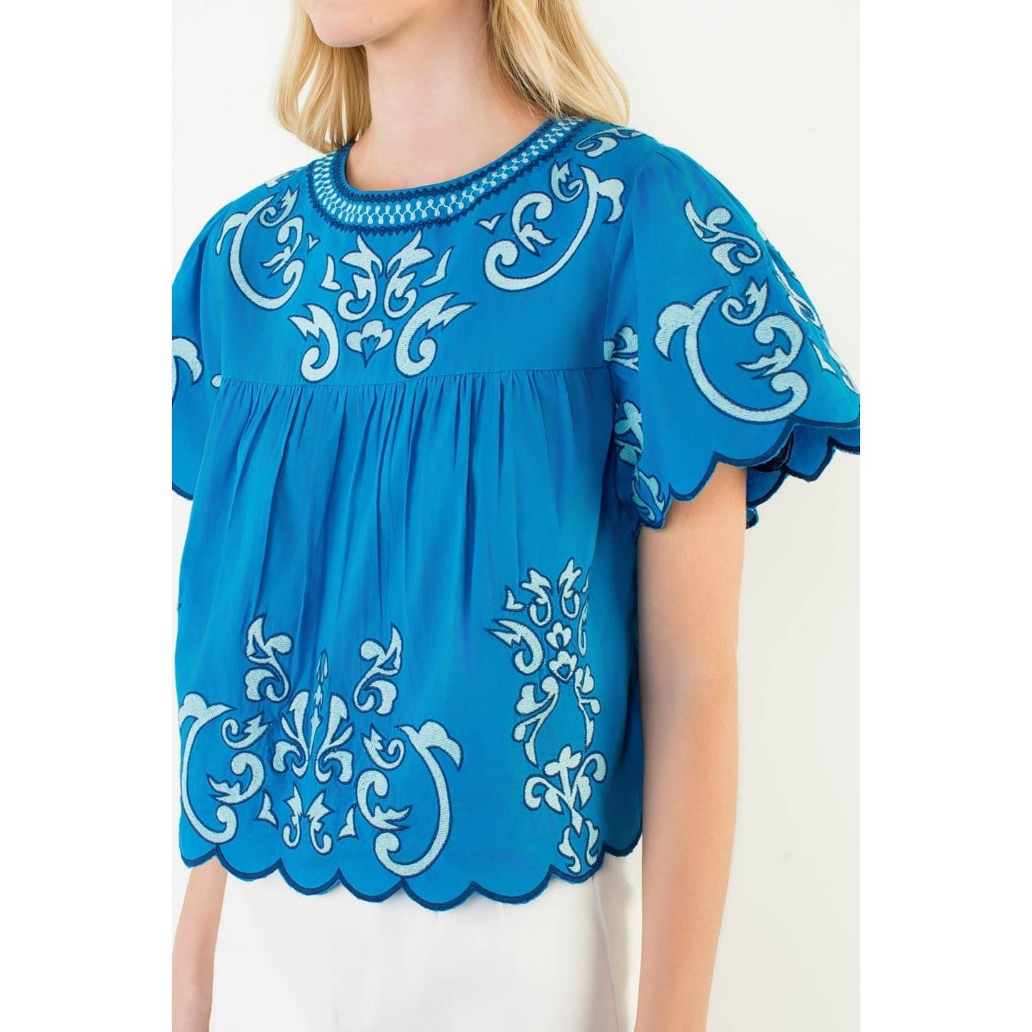 Cobalt blue Harbor Breeze Top with white scrollwork embroidery, scalloped edges, beaded neckline, and flutter sleeves in relaxed cotton babydoll fit