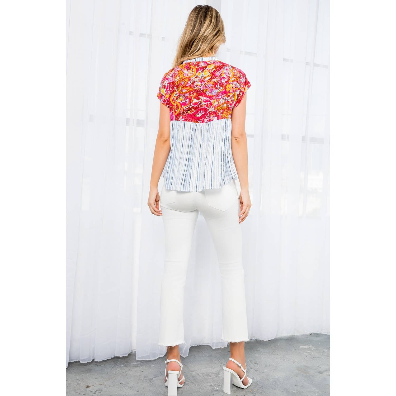 Mixed print babydoll top with bold pink paisley and blue stripe, hot pink tassels, cap sleeves, and tie neckline.